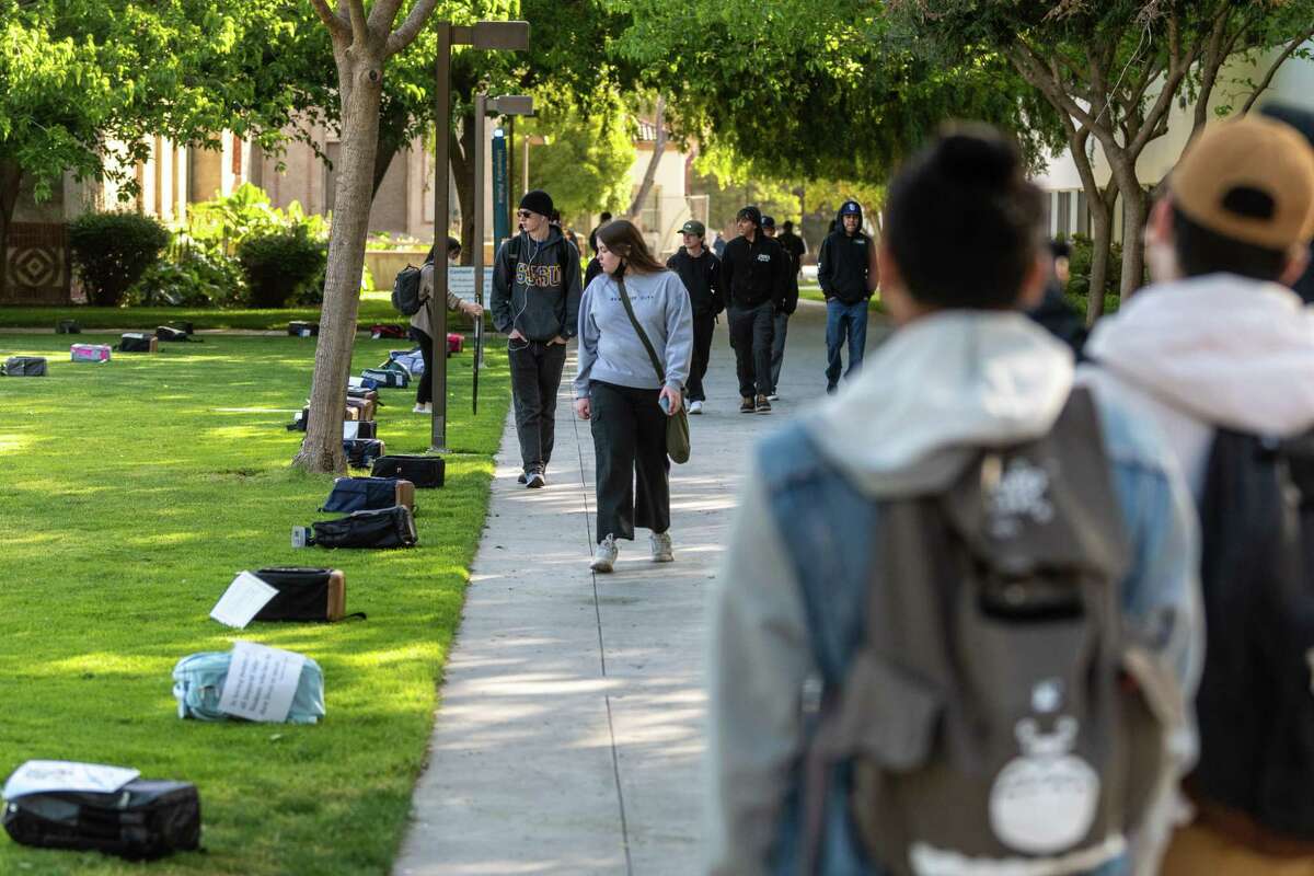 This provided photograph shows students walking past 1,000 backpacks displayed across Tower Lawn at San Jose State University as part of the day-long Send Silence Packing exhibit on Tuesday, April 12, 2022. Each backpack has a personal story or artifact from suicide survivors or people who have lost loved ones to suicide. The exhibit was hosted by Active Minds, a national nonprofit that works to challenge the stigma associated with mental illness, according to SJSU representatives.