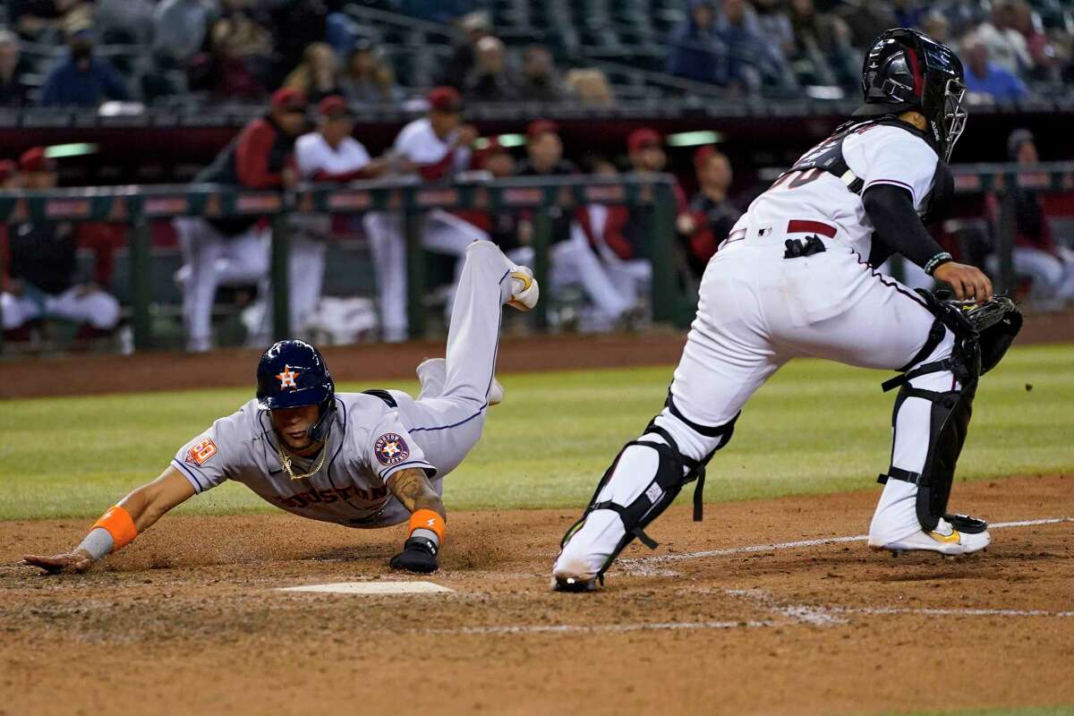 Astros runner Jose Siri slides in with the winning run on Michael Brantley's two-out RBI single in the ninth inning for a 2-1 victory over the Diamondbacks on Tuesday in Phoenix.