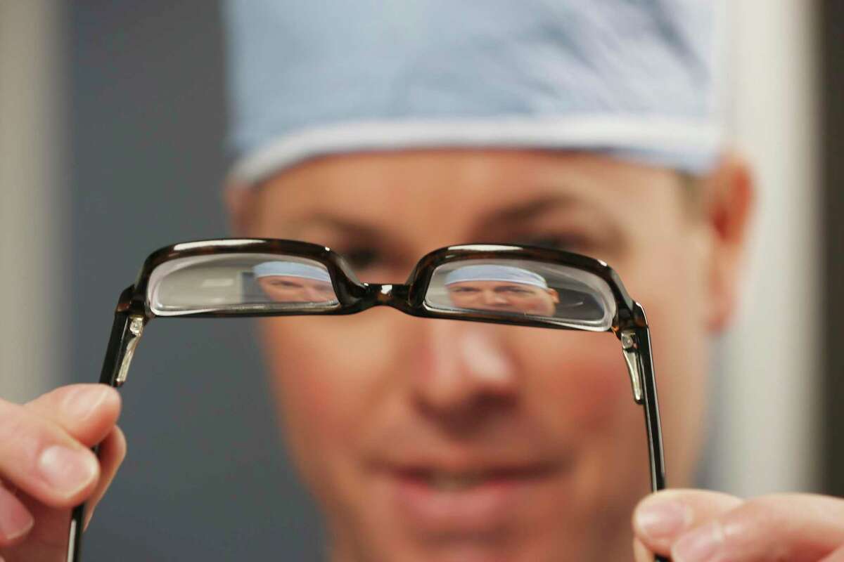 Dr. Gregory Parkhurst, of Parkhurst NuVision, hold a pair of high prescription glasses used by a patient he was preparing to perform an EVO procedure on at his clinic on Monday, April 11, 2022. The vision-correction surgery, which was recently approved by the U.S. Food and Drug Administration, involves implanting a collamer lens.