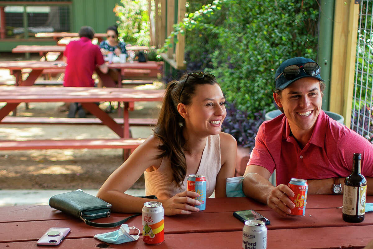 Maddie Drake (left) and and Harrison Harp sit next to each other at the West Alabama Ice House, Saturday, Oct. 3, 2020, in Houston.