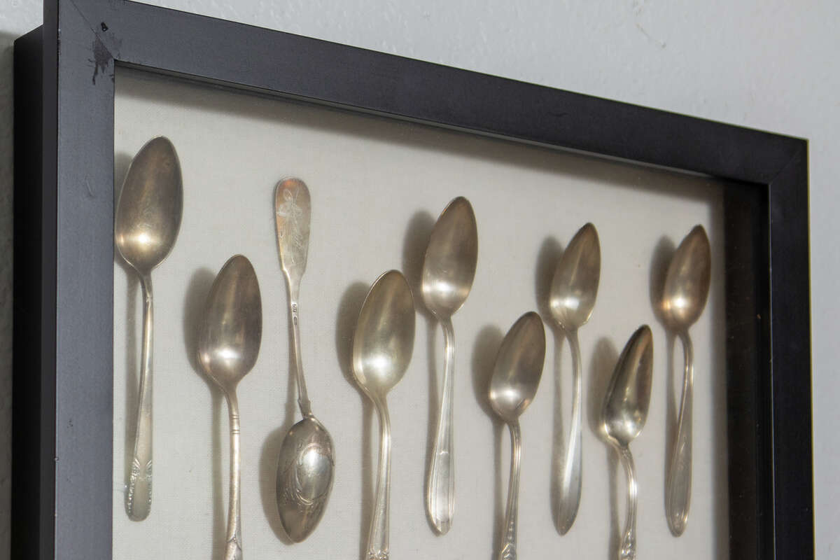 Monique Feybesse shows off spoons she received working in different kitchens in Europe that are displayed in her home kitchen in Vallejo, Calif. on April 8, 2022. Monique and her husband Paul bake all the pastries and breads created by their company Tarts de Feybesse themselves.