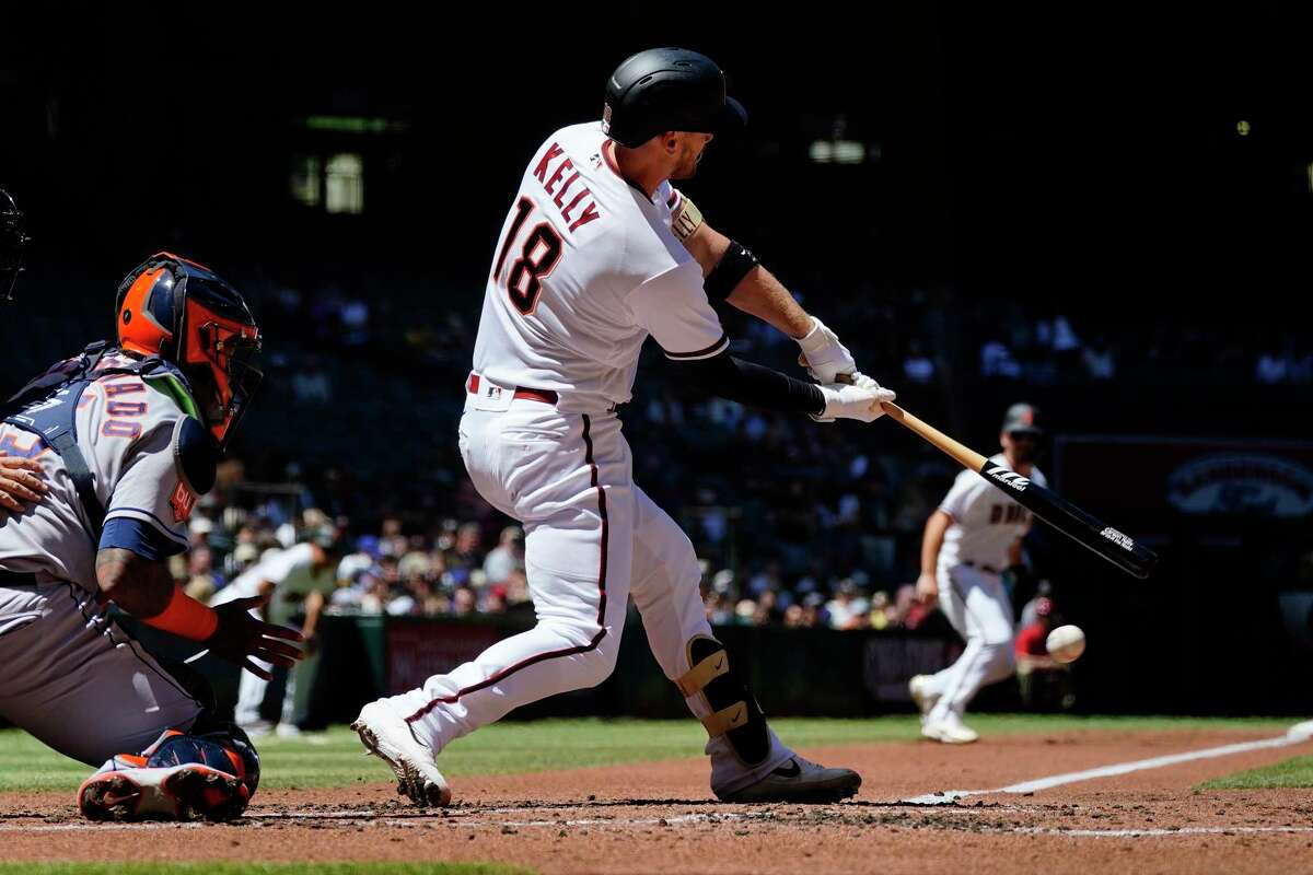 Arizona Diamondbacks' Carson Kelly (18) strikes out as Houston Astros catcher Martin Maldonado, left, looks to make a catch on the pitch during the first inning of a baseball game Wednesday, April 13, 2022, in Phoenix. (AP Photo/Ross D. Franklin)