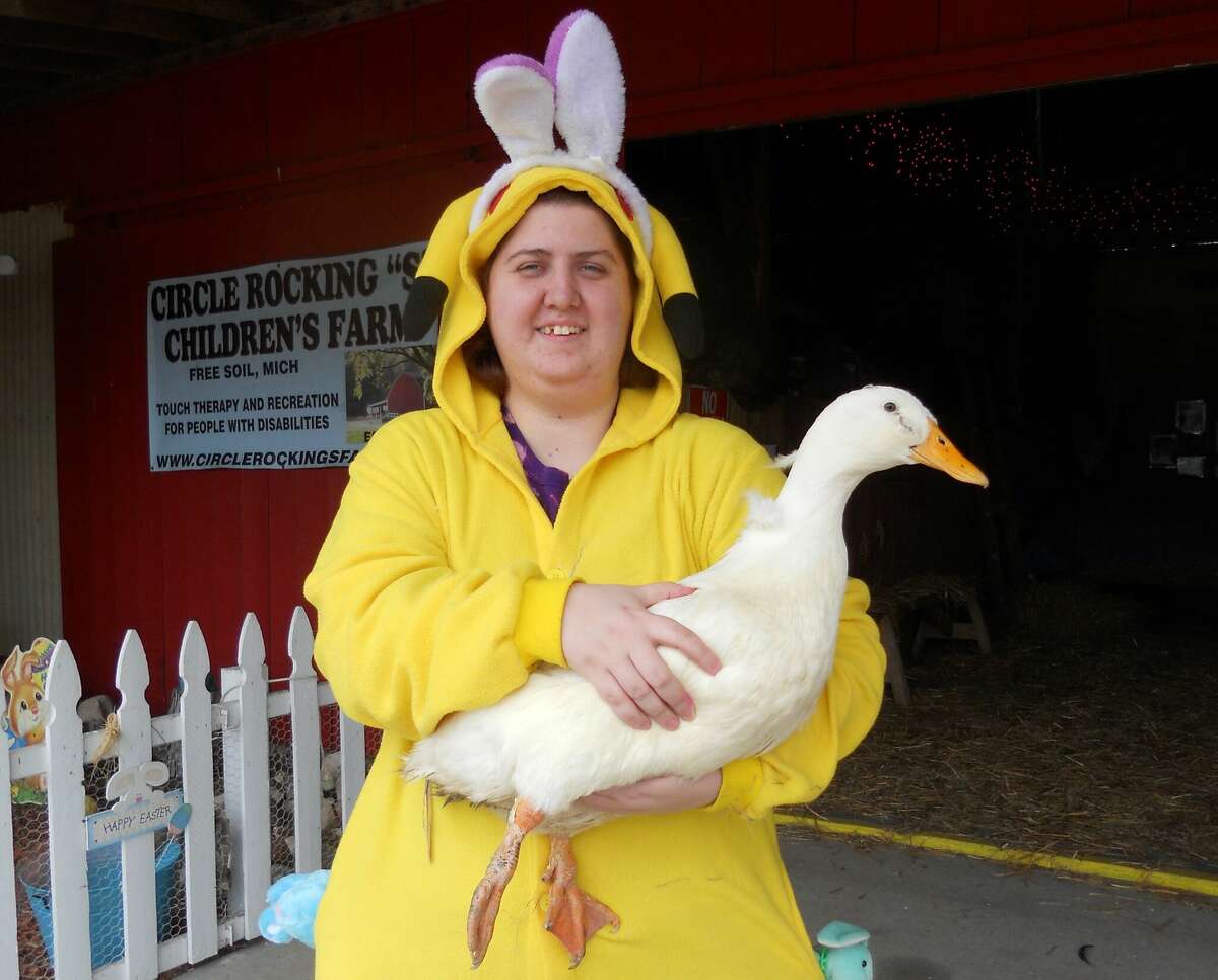 Kendra Lewis, of Bear Lake, meets a duck Tuesday during an Easter egg hunt at the Circle Rocking S Children's Farm.