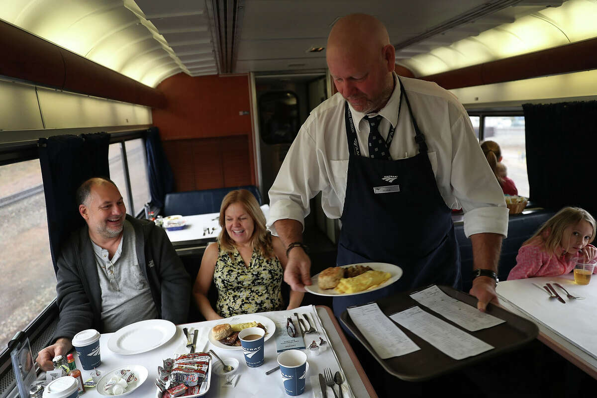 Mark Hunter serves breakfast to Bill Squier and Julie Blethen on Amtrak's California Zephyr during its daily trip to Emeryville/San Francisco from Chicago.