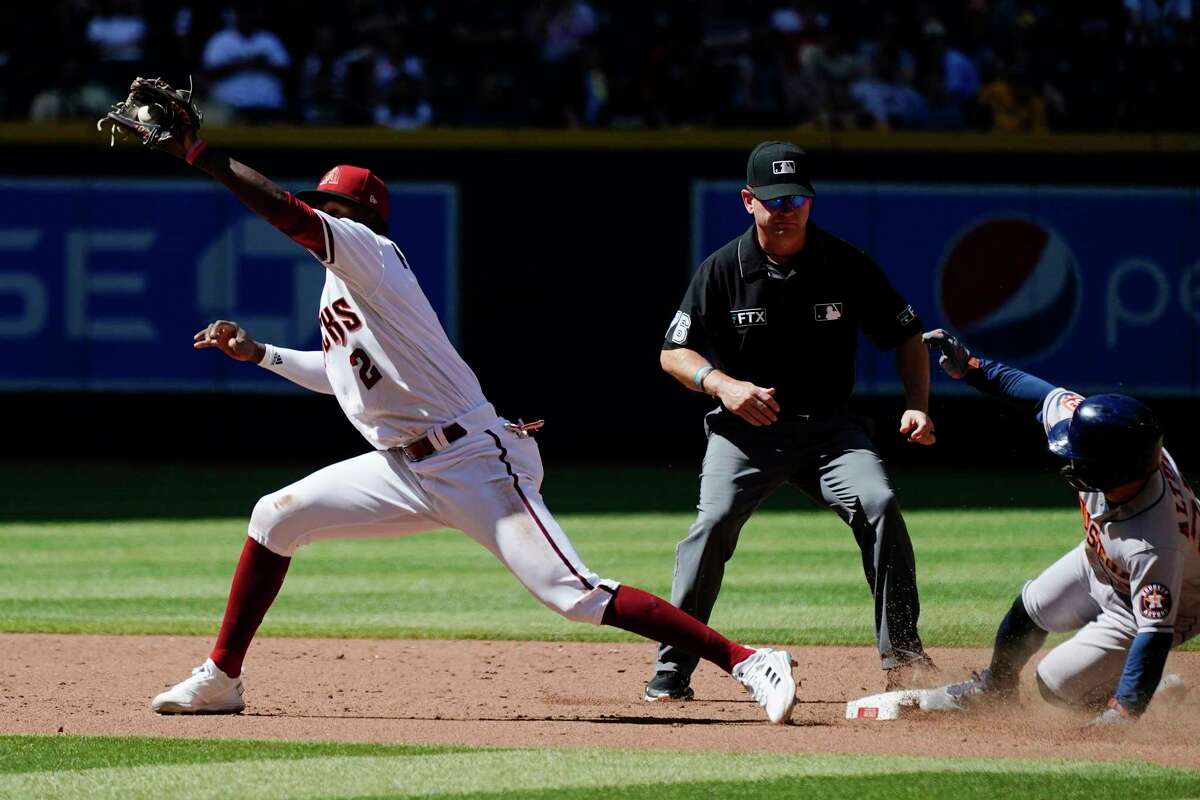 Arizona Diamondbacks shortstop Geraldo Perdomo (2) gets pulled away from second base by the throw as Houston Astros' Jose Altuve, right, steals second base, while umpire Mike Muchlinski watches during the sixth inning of a baseball game Wednesday, April 13, 2022, in Phoenix. (AP Photo/Ross D. Franklin)