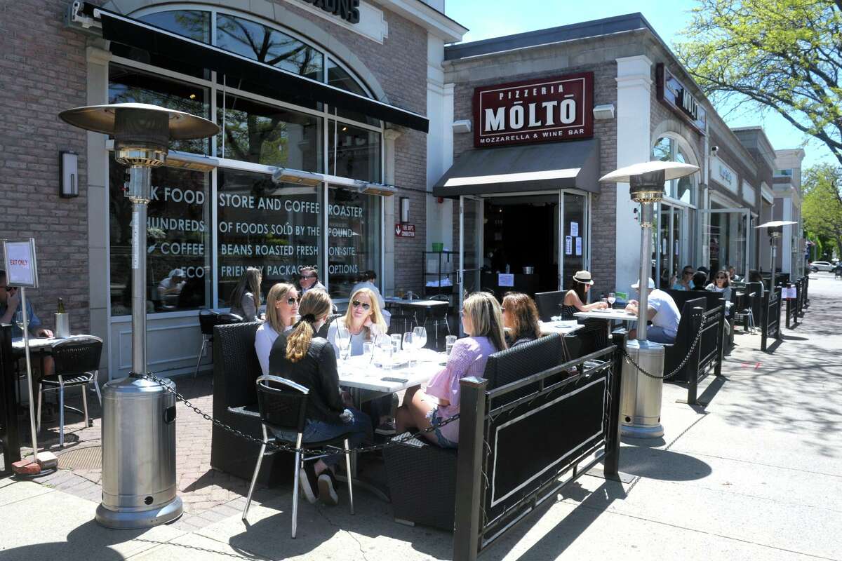 Diners sits at the outdoor tables in front of Pizzeria Molto, in Fairfield, Conn. May 20, 2020.