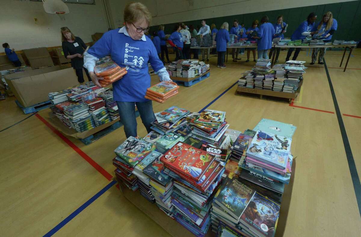 Norwalk volunteer Nancy Peters sorts books in 2017 when the employee unions last had books donated by the internation nonprofit First Book. The event returns May 21 at Norwalk High School.