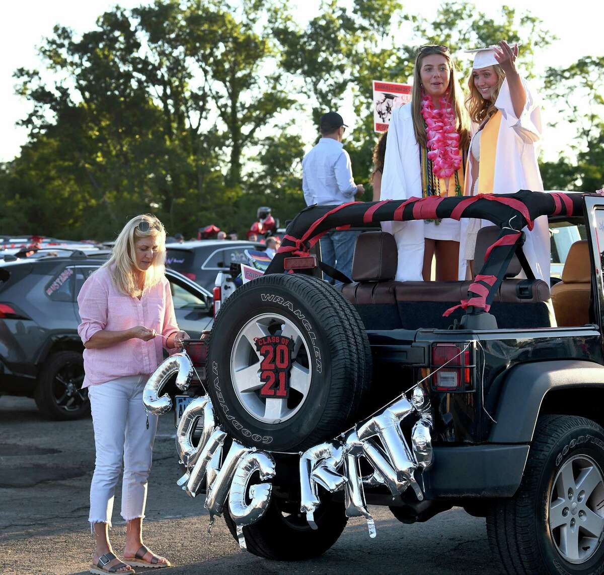 Susie Byrne decorates her car with a congratulations banner for her daughter, Brooke Byrne, with her friend Bridget Flanagan standing in the Jeep. Fairfield Warde High School held its graduation ceremony at Jennings Beach in Fairfield, Tuesday evening, June 15, 2021.