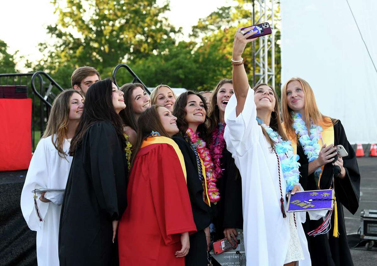 Jillian Motkin takes a selfie photo with a group of fellow graduates before the start of the Fairfield Warde High School graduation ceremony at Jennings Beach on June 15, 2021.
