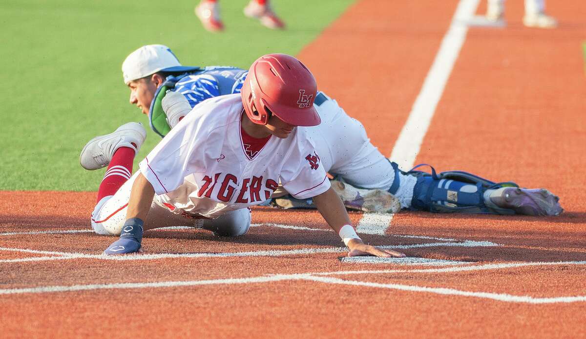Martin High School’s Aldo Alarcon safely slides into home plate during a game against Veterans Memorial High School, Tuesday, April 12, 2022 at Veterans Field.