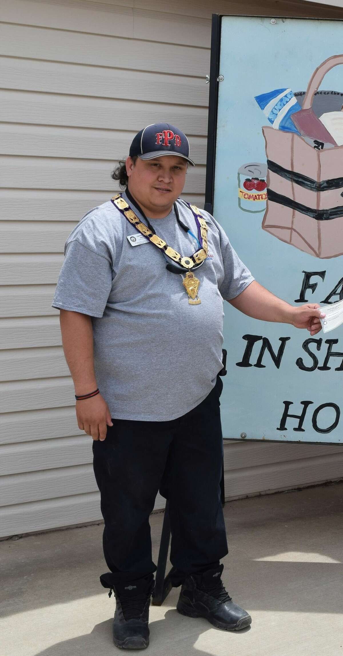 Harrison Hart, on behalf of the Plainview Elks Lodge, presents a donation to Faith In Sharing House on May 15, 2020.  (File Photo: May 15, 2020)