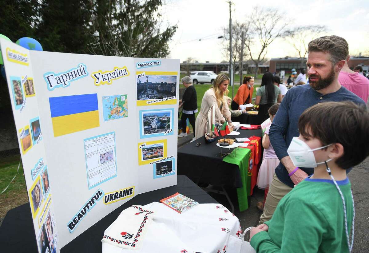 Parkway School teacher Christian Wolfgruber, right, made a Ukraine exhibit with his Ukrainian student for International Night at the school in Greenwich, Conn., on Wednesday, April 13, 2022.