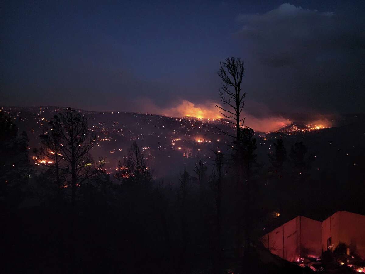 Fire burns along a hillside in the Village of Ruidoso, N.M., on Wednesday, April 13, 2022. Officials say a wildfire has burned about 150 structures, including homes, in the New Mexico town of Ruidoso. (Alexander Meditz via AP)