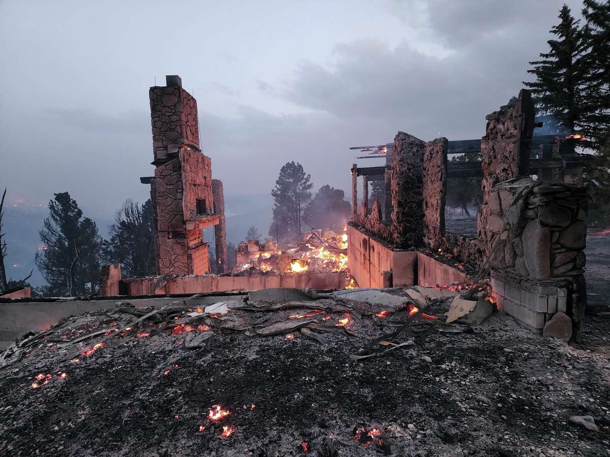 The remains of a home left after a wildfire spread through the Village of Ruidoso, New Mexico, on Wednesday, April 13, 2022. Officials say a wildfire has burned about 150 structures, including homes, in the New Mexico town of Ruidoso. (Alexander Meditz via AP)