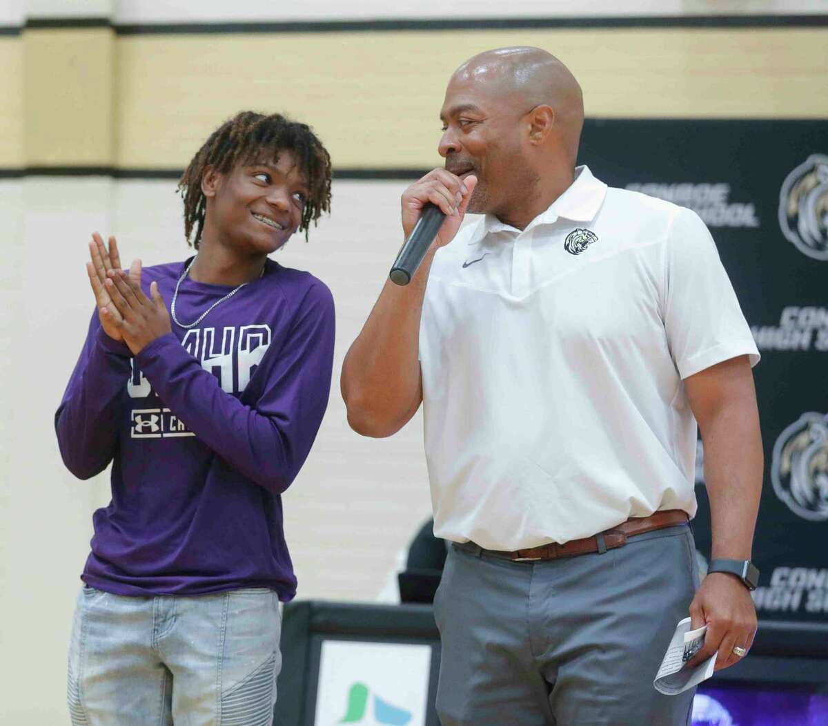 Bradin Bradford shares a moment with head football coach Cedric Hardeman before signing to play foot ball for Mary Hardin-Baylor University during an athletic signing ceremony at Conroe High School, Thursday, April 14, 2022, in Conroe.