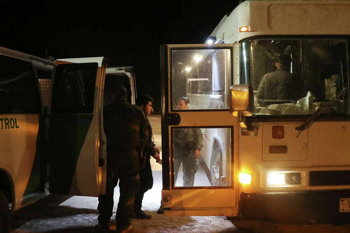 Migrants are moved from a van into a bus after they were detained by U.S. Border Patrol agents in La Joya, Texas, Monday, April 4, 2022. Gov. Greg Abbott’s border crackdown is producing a bonanza of no-bid contracts, showering tens of millions of dollars on staffing companies, technology firms and jail builders, including one California-based business that sold Texas hundreds of millions of dollars-worth of unreliable Covid tests before the FDA revoked their authorization last year.
