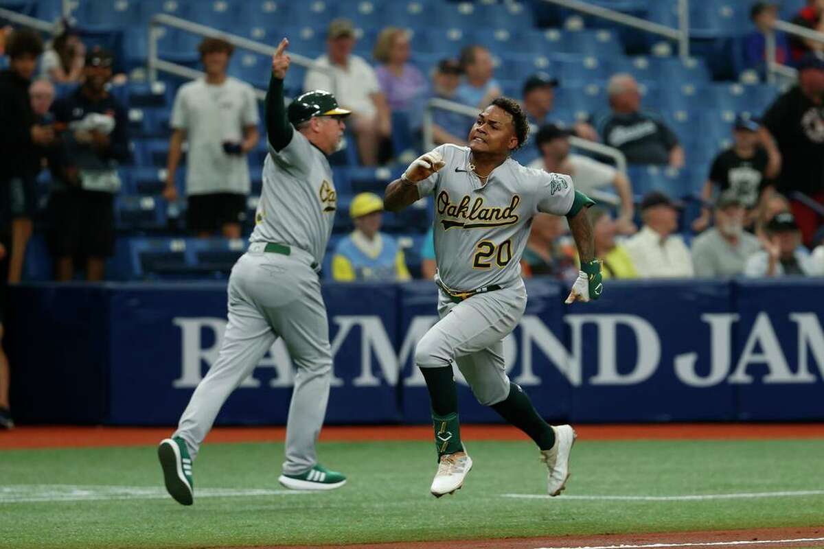 Oakland Athletics Cristian Pache runs home to score past third base coach Darren Bush against the Tampa Bay Rays during the second inning of a baseball game Thursday, April, 14, 2022, in St. Petersburg, Fla. (AP Photo/Scott Audette)