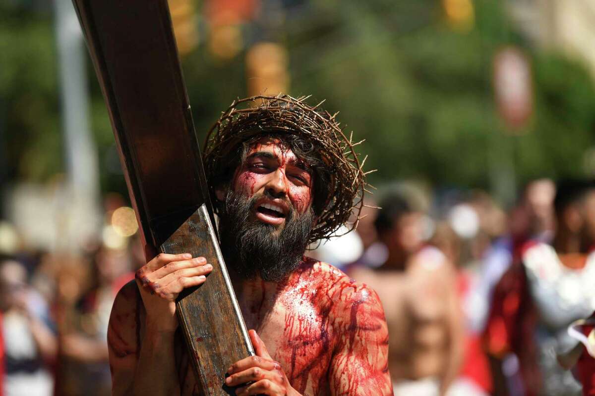 Jesus, played by actor Charles Ramirez, carries the cross along Santa Rosa Street during the annual San Fernando Cathedral Passion of Christ reenactment on Good Friday, April 19, 2019. The play depicts the final hours of the life of Jesus Christ on the day that he was crucified almost 2,000 years ago.