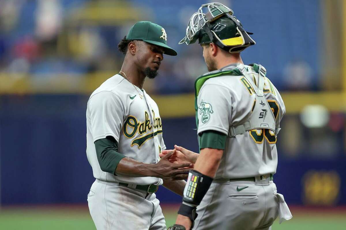 Dany Jimenez #56 of the Oakland Athletics celebrates with Austin Allen #30 after a win over the Tampa Bay Rays in a baseball game at Tropicana Field on April 14, 2022 in St. Petersburg, Florida. (Photo by Mike Carlson/Getty Images)