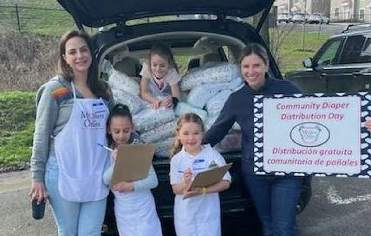 Volunteers from Mothers for Others distribute a week’s worth of free diapers to local families recently. One of the distribution spots was Armstrong Court in Western Greenwich. The volunteers were mothers and daughters, including, from left, Suleima Mohamed Cepeda, Valentina Cepeda, Caroline Peyton, Nina Moody and Lisa Moody.