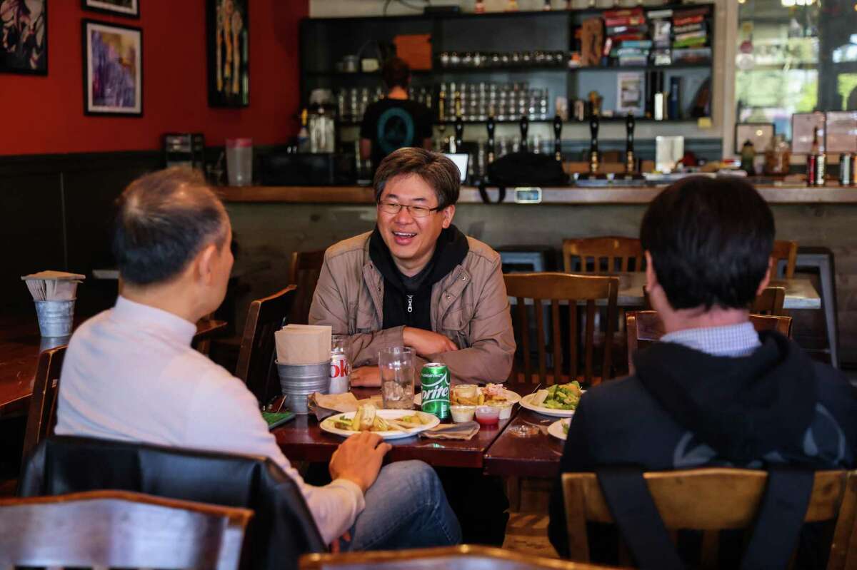Hyun Shin (facing camera) and Sang Duk (right) dine at Freewheel Brewing Co. in Redwood City.