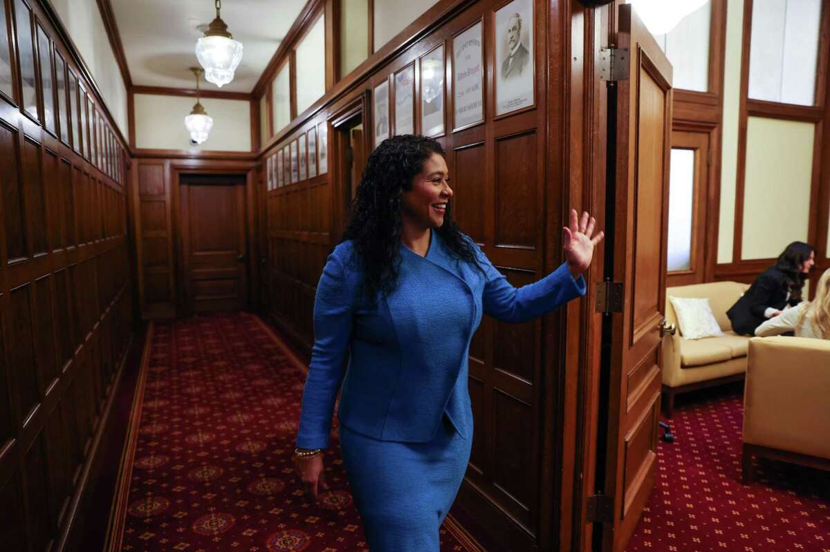San Francisco Mayor London Breed waves to her staff before a meeting.