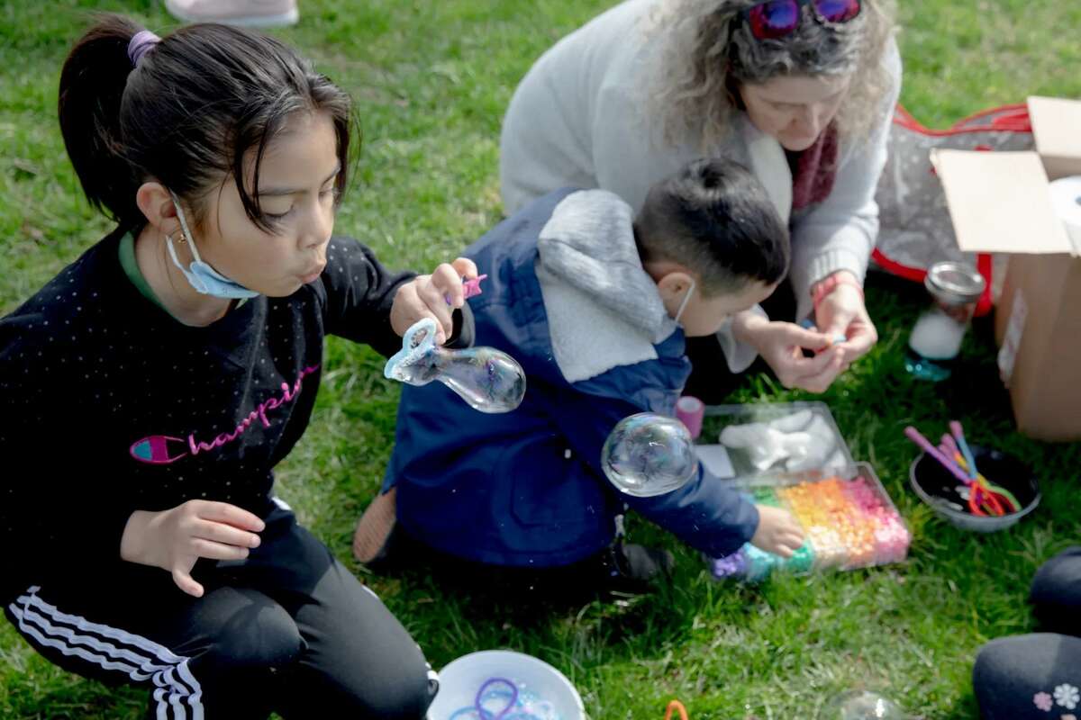 hesia Mejia, 8, left, blows bubbles during a protest to expand HUSKY Health to all immigrants in Connecticut, starting with minors under 18 this year. As an undocumented minor, Shesia will be eligible for HUSKY Health Program beginning Jan. 1, 2023, but with the current system, she will lose the eligibility in a few months when she turns nine.