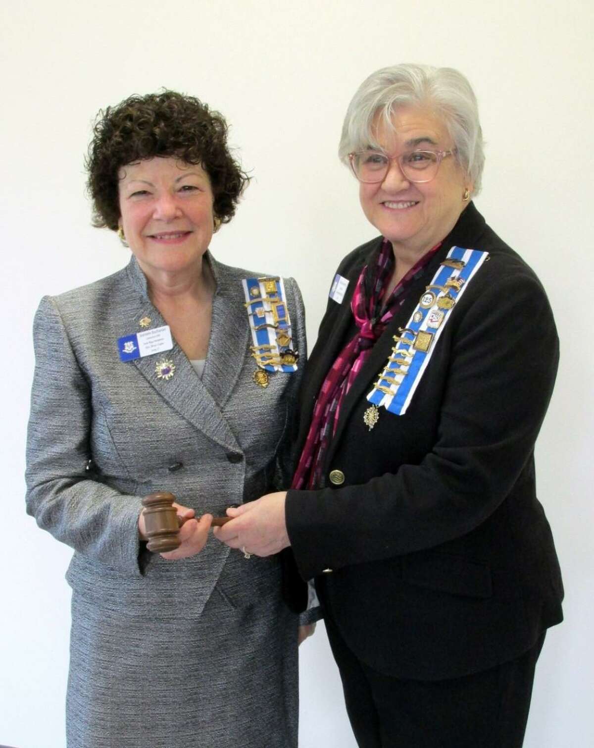 Newly elected National Society Daughters of the American Revolution Sarah Riggs Humphreys-Mary Silliman Chapter Regent Jeaneen Buchanan is handed the gavel by outgoing Regent Patricia King.