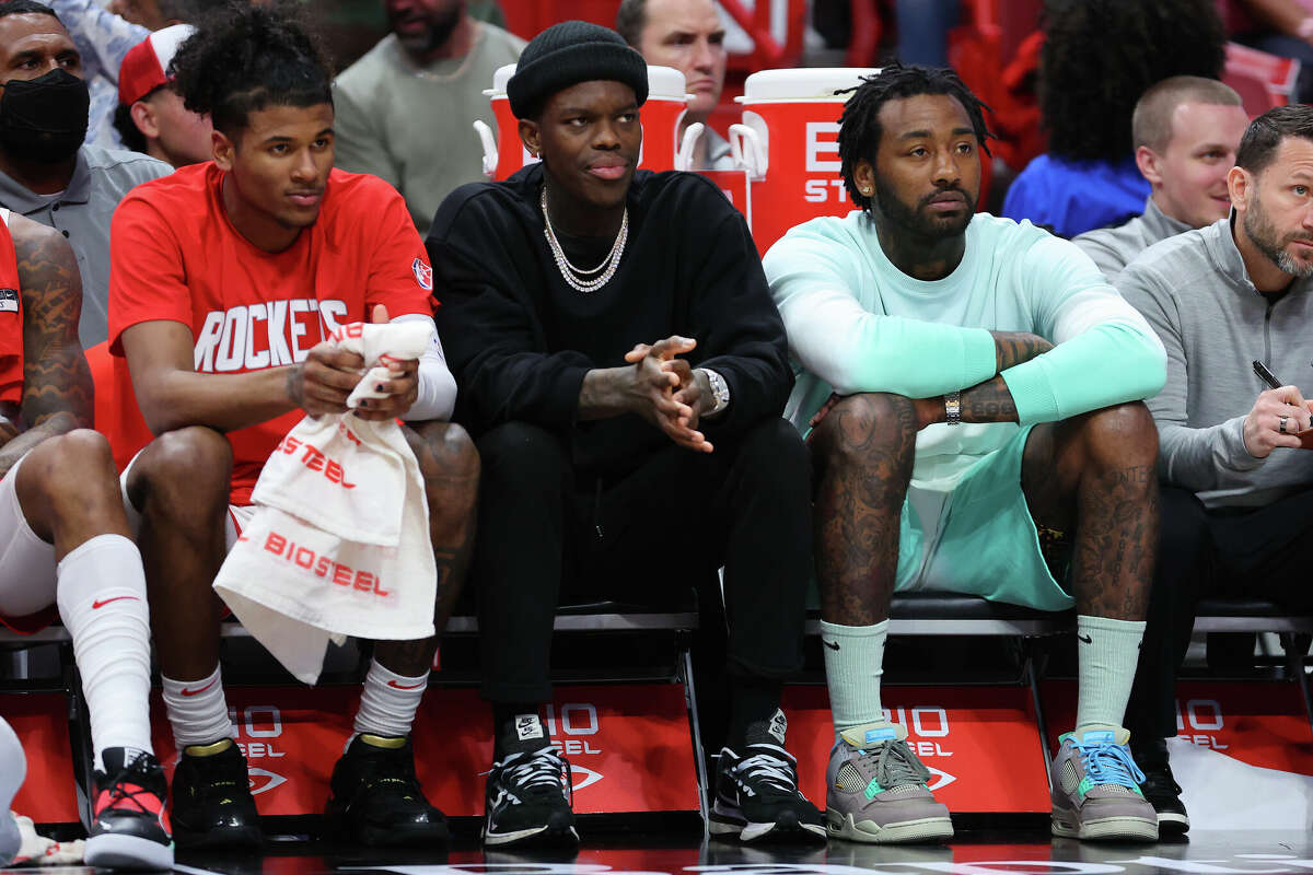 Jalen Green (left), Dennis Schroder (center) and John Wall (right) of the Houston Rockets look on against the Miami Heatduring the first half at FTX Arena on March 7, 2022 in Miami, Florida.