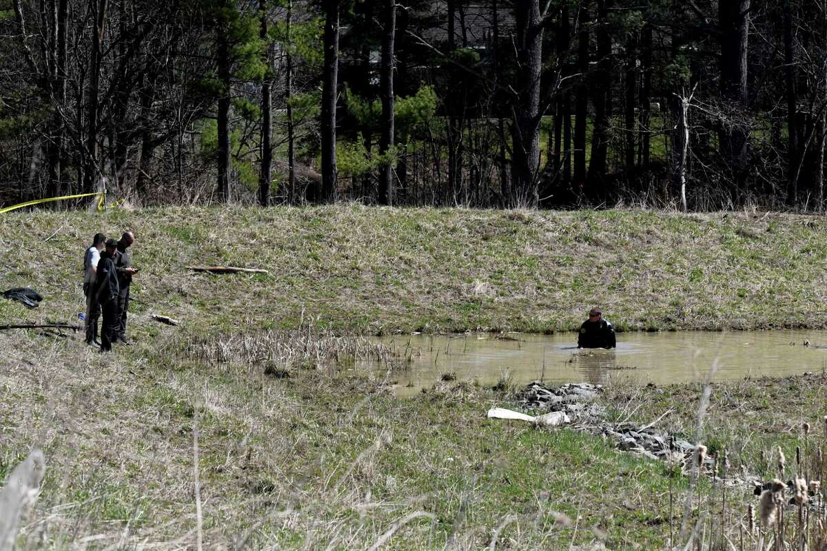 A State Police diver searches a storm runoff pond near 120 Miller Rd. in New Scotland where a 35-year-old physician's assistant from St. Peter's Hospital was slain Wednesday.
