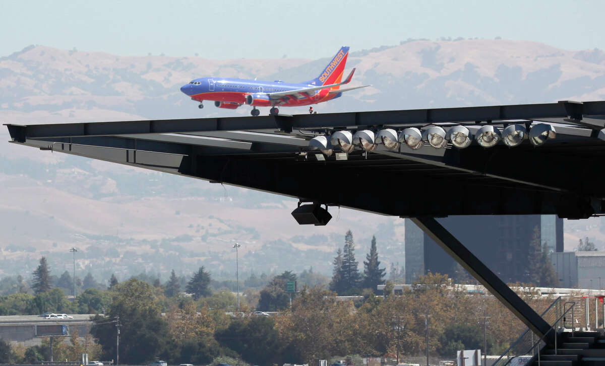 A Southwest Airlines jet landing at Mineta San Jose International Airport passes behind the roof line of the San Jose Earthquakes new stadium under construction in September 2014.