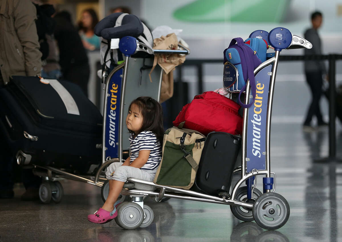 A young passenger waits on a cart at a ticket counter at San Francisco International Airport in July 2013.