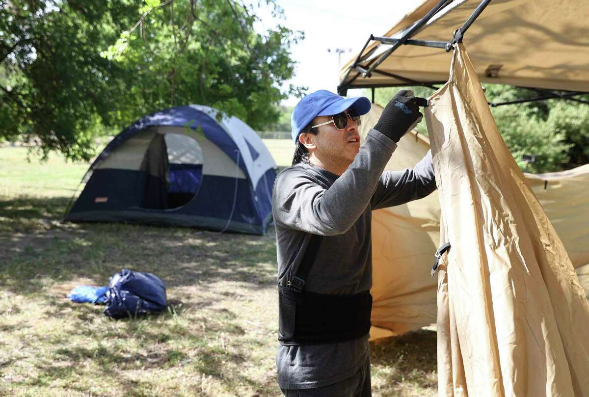 Daniel Hernandez pitches tents Thursday at Brackenridge Park in preparation for the Easter holiday weekend. Hernandez said his family has camped at the park for about 30 years.