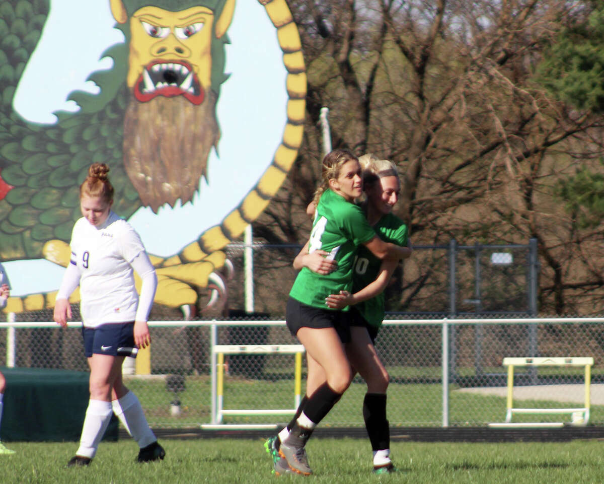 Southwestern's Mac Day (10) and Morgan Durham hug as they celebrate a goal by Day Thursday against Pana in at Southwestern as Pana's Kassie Weideman walks away