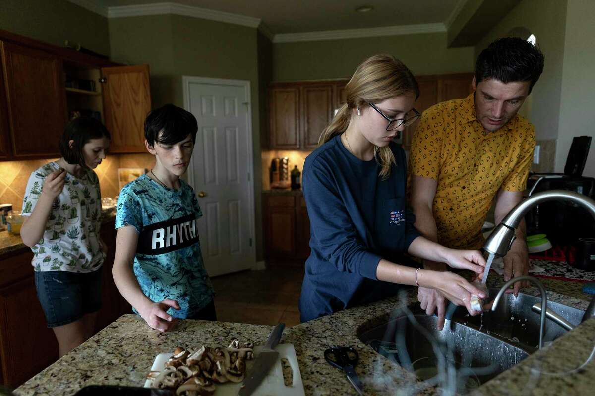 Dmytro Kovalskyy (far right), his daughter Ivana and niece and nephew Sasha and Bazhen work on preparing dinner. Sasha and Bazhen arrived in San Antonio after fleeing Ukraine and will be staying with their uncle and his family.