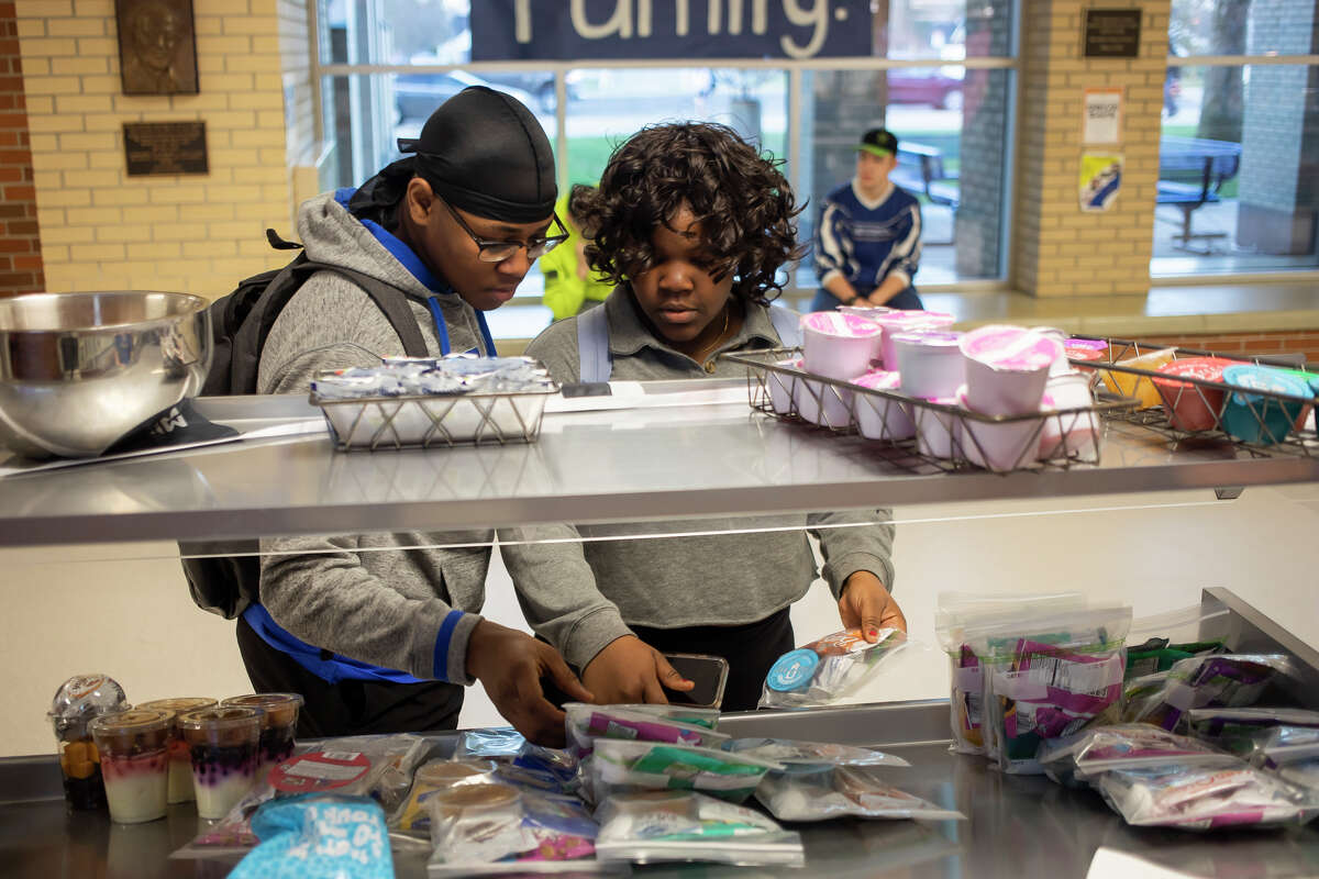 Midland High junior Daniel Abikphi, left, and sophomore Excellent Abikphi, right, pick up a free breakfast before a day of PSAT, SAT and state testing is administered to students Thursday, April 14, 2022 at Midland High School.