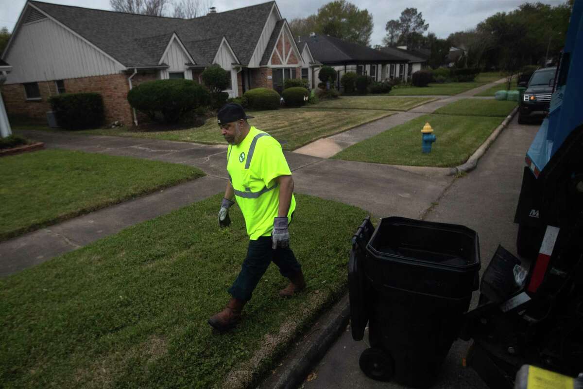 City of Houston Solid Waste Dept. trash truck driver Anthony Senegal, 56, returns to the trash truck after accommodating a trash bin to be picked up by the truck’s mechanical arm, Tuesday, March 29, 2022, in Houston.