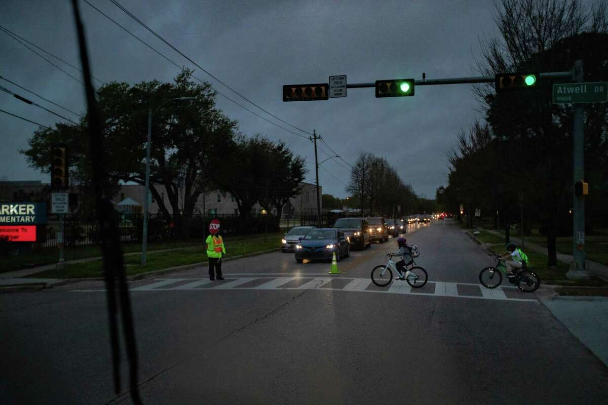 Children ride their bicycles on their way to school in the morning, Tuesday, March 29, 2022, in Houston.