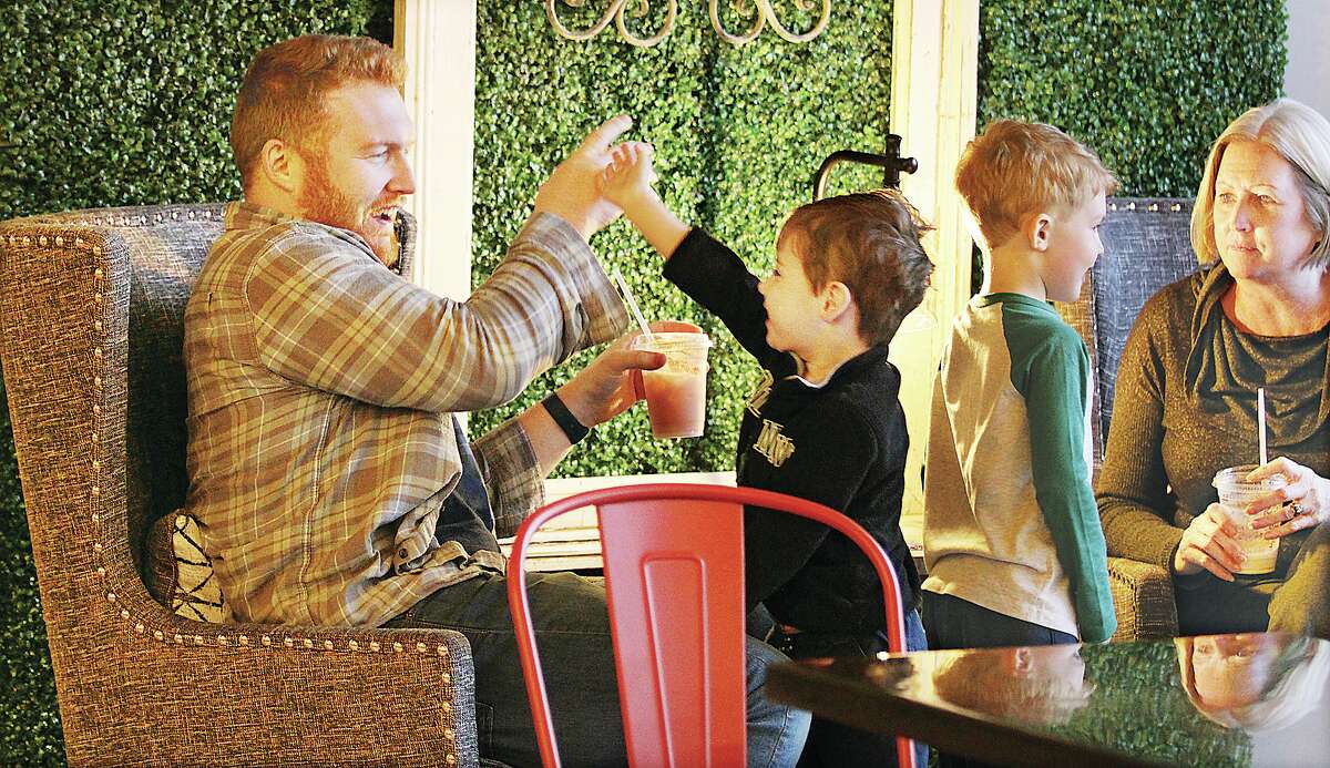 John Badman |  Telegrapher Matthew Brynildsen, left, of Godfrey plays with Jameson Kuehnel, 3, Friday during the soft opening of the new Germainia Brew Haus location at 309 N. State Street in Jerseyville.  Kuehnel is the son of store manager Jamie Kuehnel.  Dozens of people enjoyed coffee drinks in a home environment on Friday on the first day of activity at Germania's fourth location, which features darker, dimmer lighting.  People gathered at tables to have drinks and chat in the 6,000 square foot building which will be open from 6 a.m. to 1 p.m. seven days a week.  Plans also call for a drive-thru in early May.