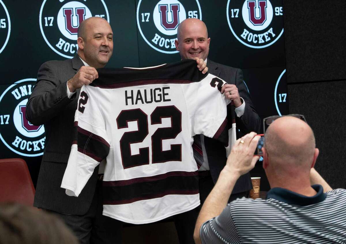Union’s Athletic Director Jim McLaughlin, left, and new hockey coach Josh Hauge hold up Haughe’s new jersey during a press conference announcing his new position on campus Friday, April 15, 2022 in Schenectady, N.Y.