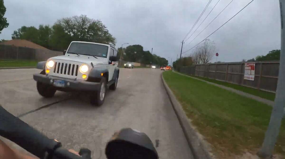 The driver of a Jeep swerves into oncoming traffic and narrowly misses hitting a cyclist on Georgia Avenue in Deer Park on Wednesday, April 13, 2022.