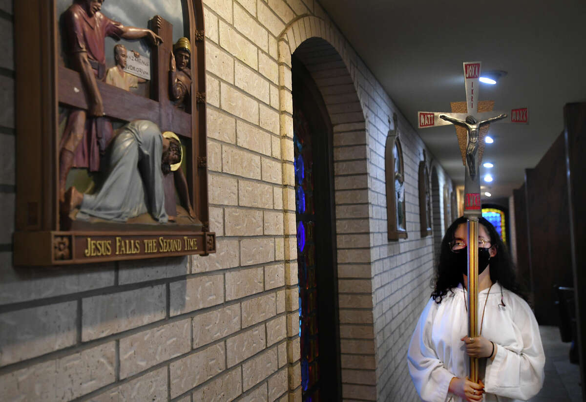 A server makes her way through the stations of the cross as Fr. Urban Ramirez leads the service on Good Friday at Our Lady of Guadalupe Church in Port Arthur. Photo made Thursday April 15, 2022. Kim Brent/The Enterprise
