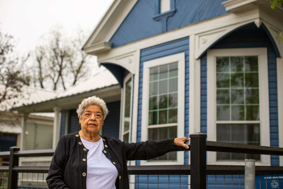 Beatrice Cortez stands in front of a home she and her late husband paid off after their son passed away. She and the rest of her neighborhood are now struggling to keep up with increasing property taxes, and many are worried they’ll lose their homes. (Kaylee Greenlee Beal/Contributor)