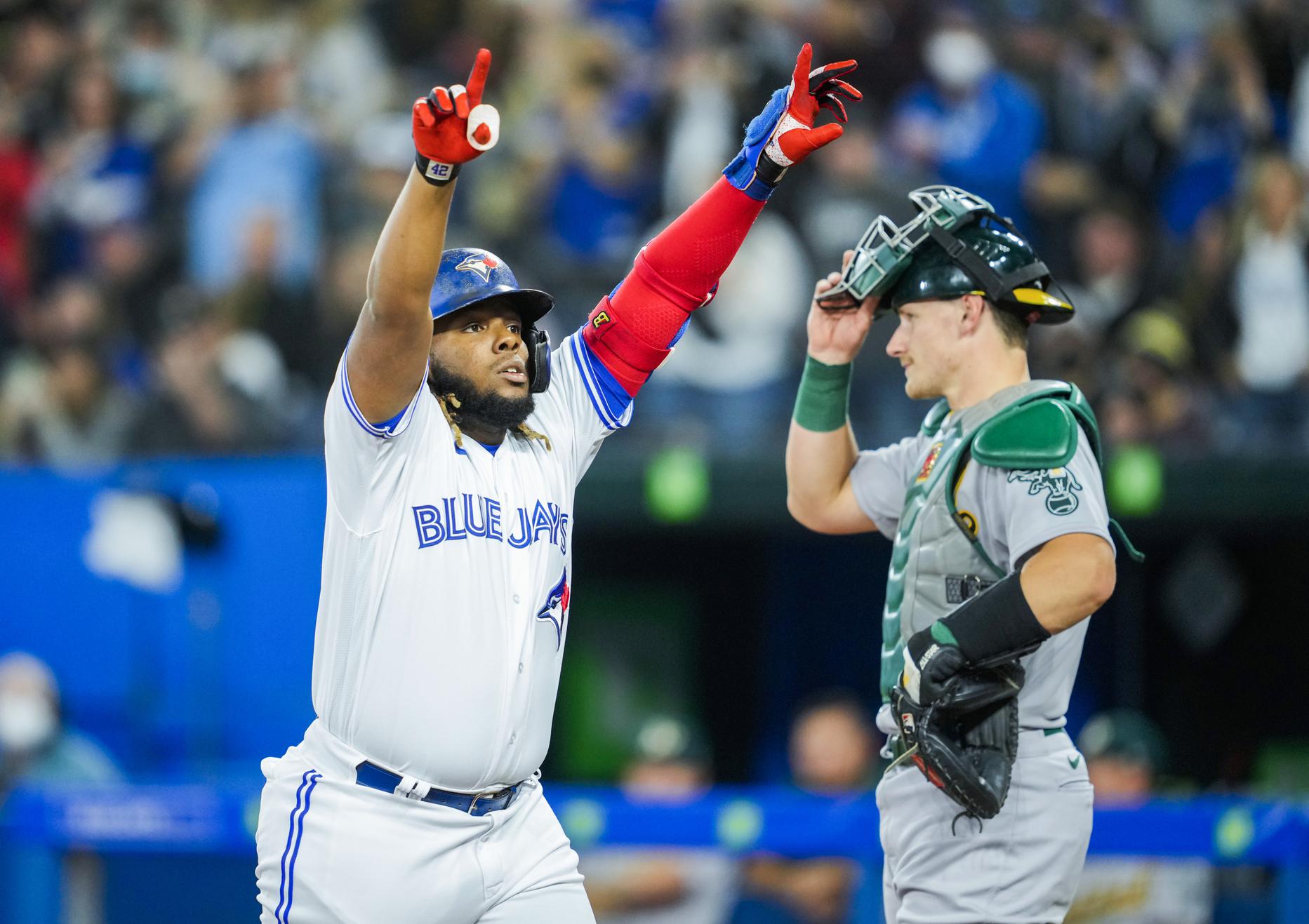 Santiago Espinal of the Toronto Blue Jays celebrates with Vladimir News  Photo - Getty Images