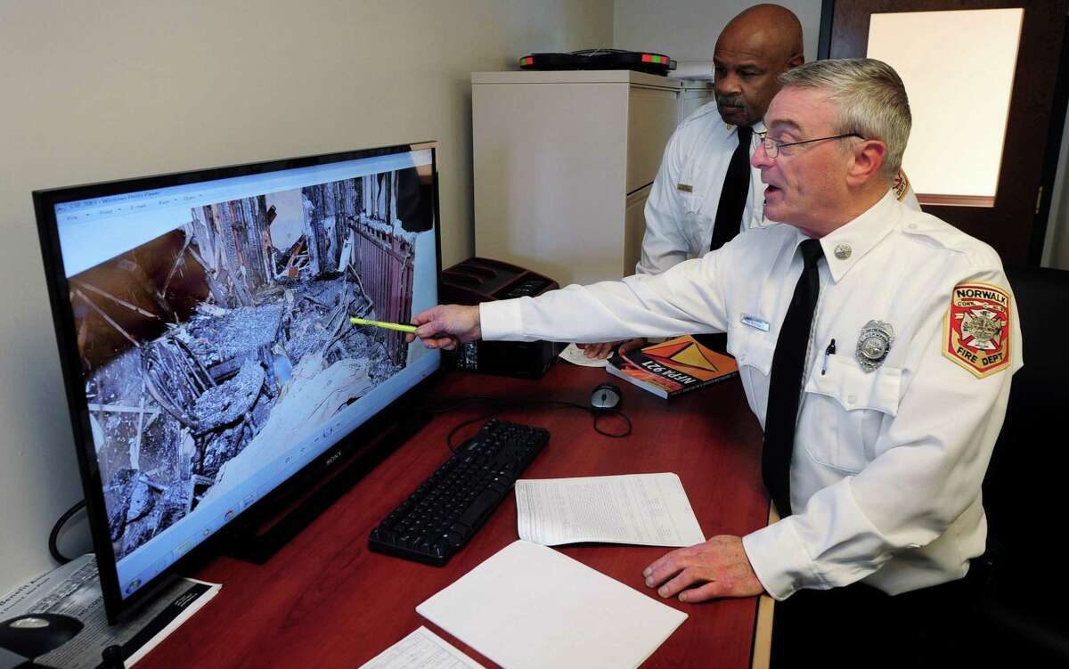 FIRE PHOTO: Norwalk Fire Marshal Broderick Sawyer and Deputy Fire Marshal Kirk McDonald point out methods of detecting the source of a fire.