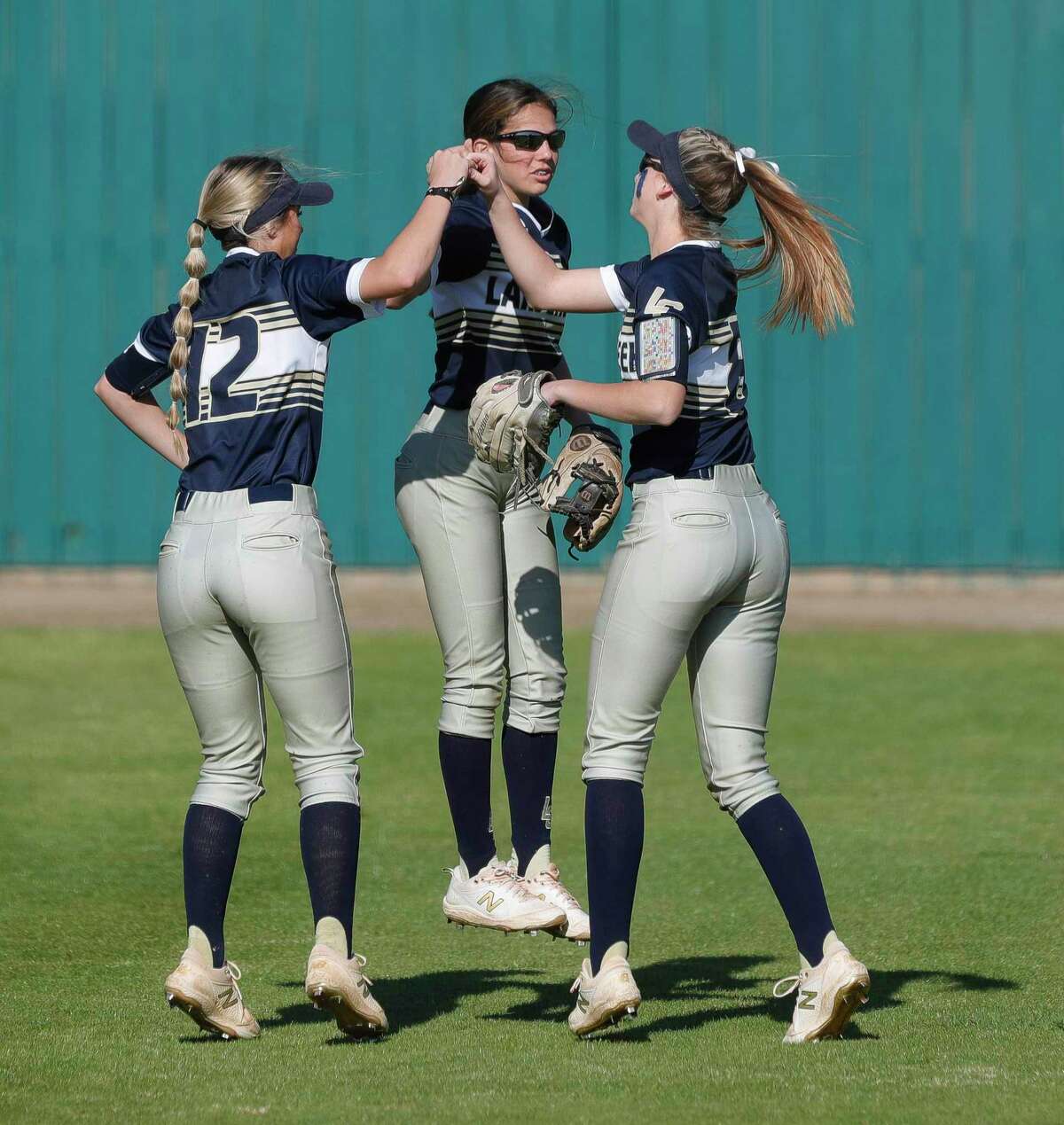Lake Creek left fielder Piper White, center fielder Carmen Uribe and right fielder Shelby Winn gather before the first inning of a District 20-5A high school softball game, Tuesday, March 15, 2022, in Montgomery.