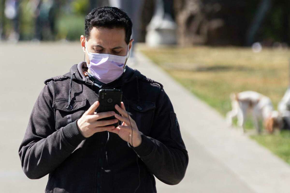 People have different immune responses to COVID: Despite exposure, some don’t seem to catch the coronavirus at all, while others, even vaccinated people, are getting infected several times. A person wears a mask while walking through Dolores Park in San Francisco in March.