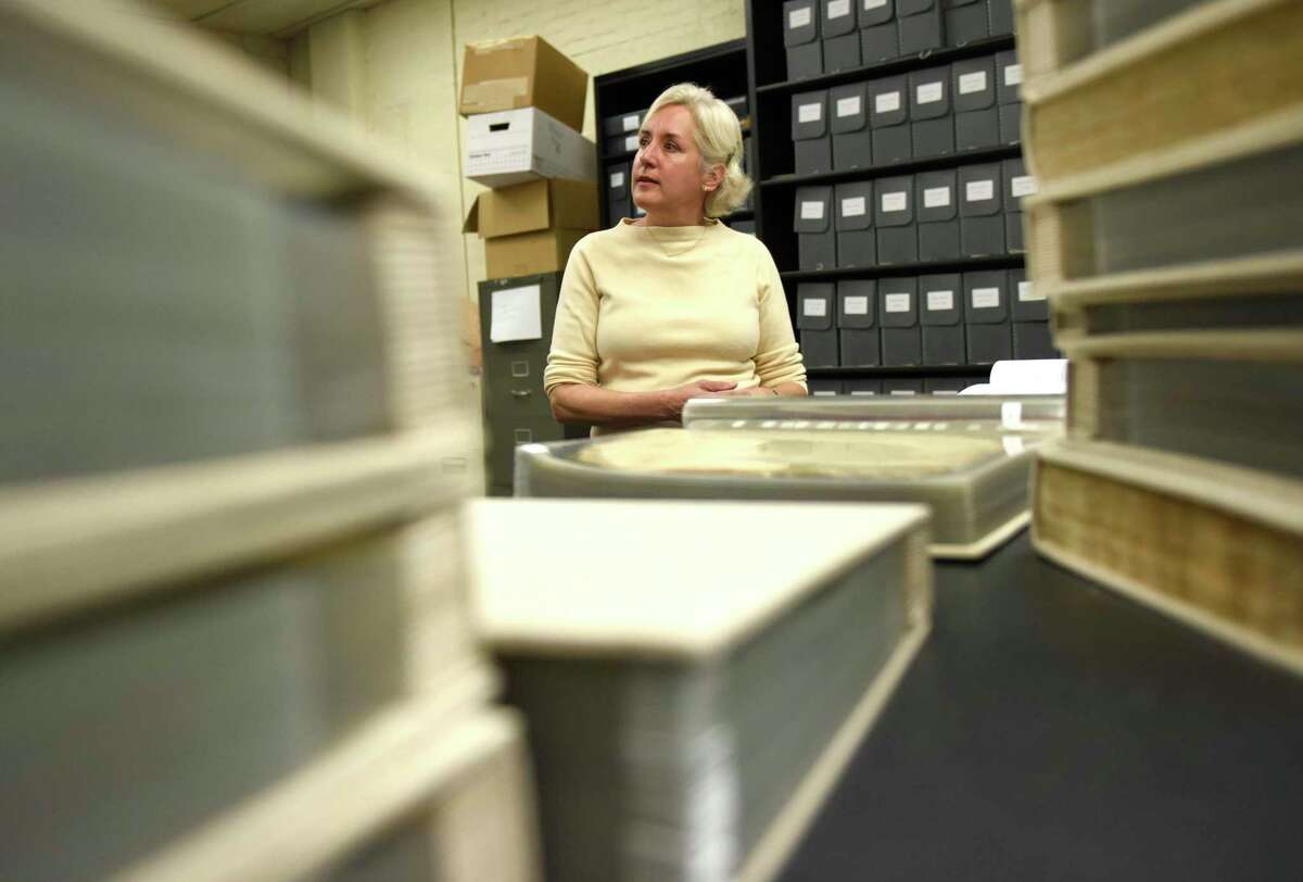 Historian Missy Wolfe chats between piles of Greenwich original historical documents about her new book "The Great Ledger: Records of the Town of Greenwich Connecticut 1640-1742" in the town archives at Town Hall in Greenwich, Conn. Thursday, April 14, 2022. Wolfe has transcribed hundreds of pages of Greenwich's historical documents from the 1600s and 1700s into a concise and accurate historical record.