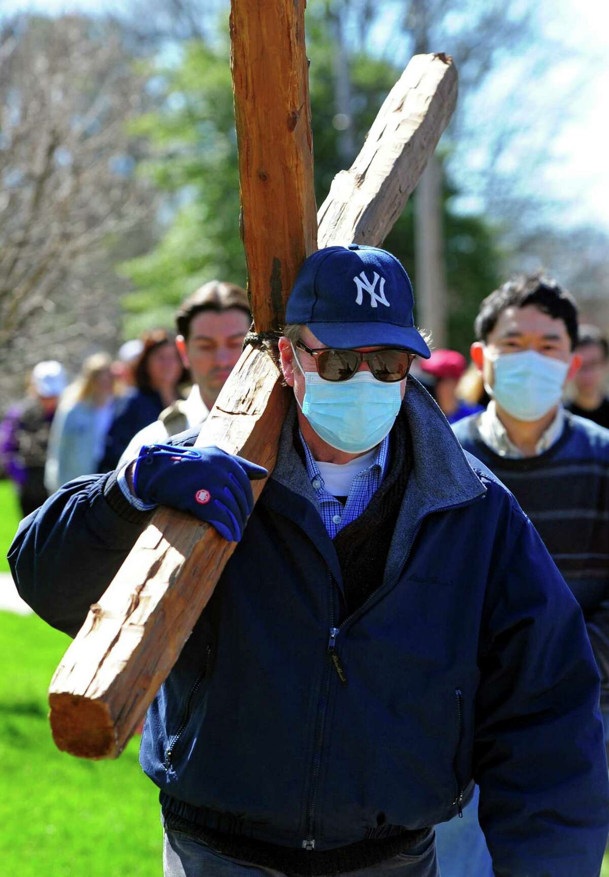 Steve Knowles first volunteers to carry a roughly hewn wooden cross with congregants from the First Congregational Church of Darien and St. Luke's Darien Parish, who gathered to walk with the cross along Post Road on Good Friday in Darien, Connecticut, Friday, April 15, 2022. About 50 people walked 13 stops along the route that represent the 13 stations of the cross.  The prayers read at each stop were tailored to each location, such as one for the fire department and one for the train station.