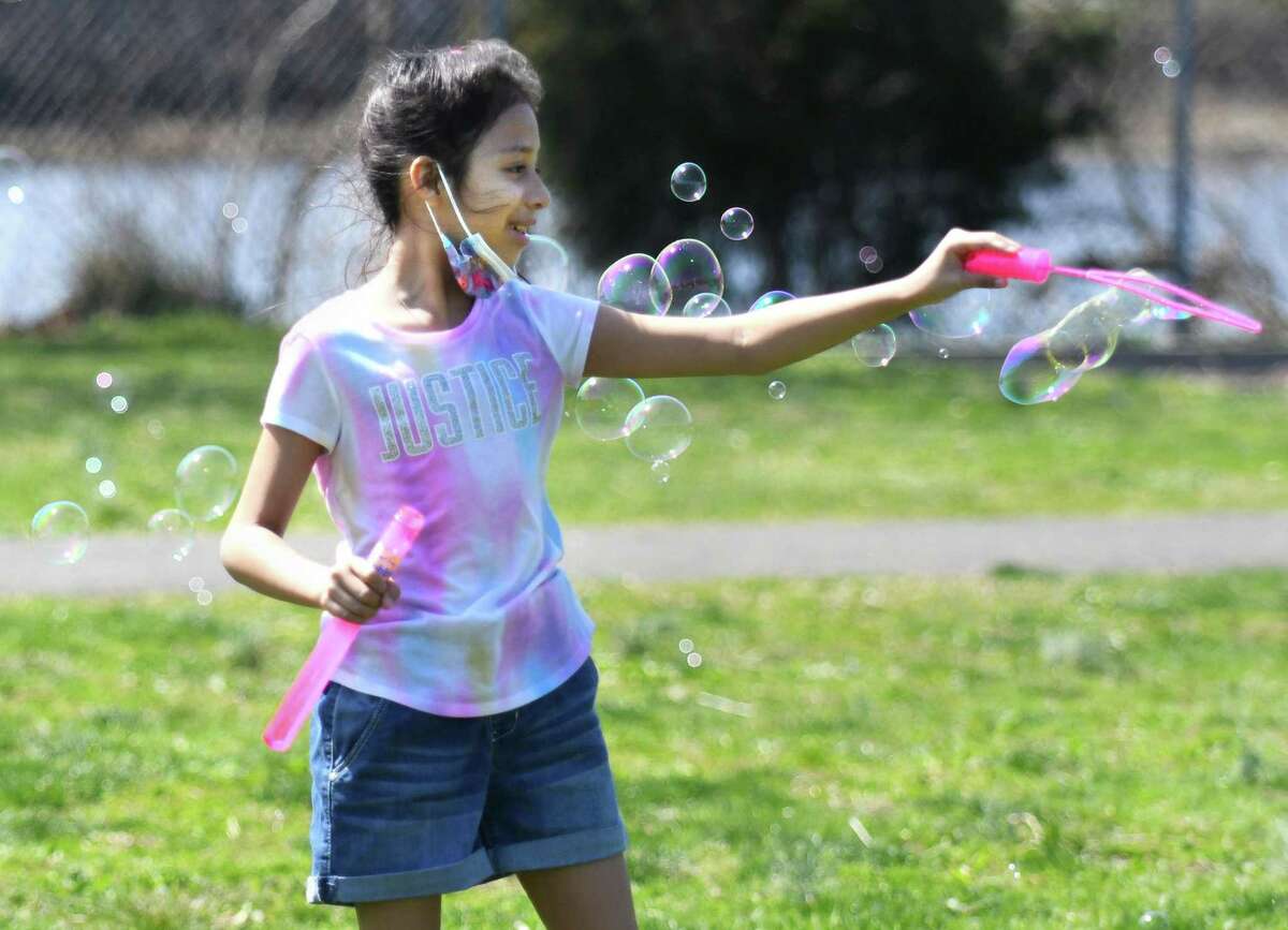 Stamford's Melanie MacDonald, 9, makes bubbles by the beach at Cove Island Park in Stamford, Conn. Thursday, April 14, 2022. Stamford's high temperature Thursday reached the mid-70s.
